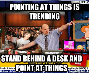 pointing at things is trending stand behind a desk and point -
